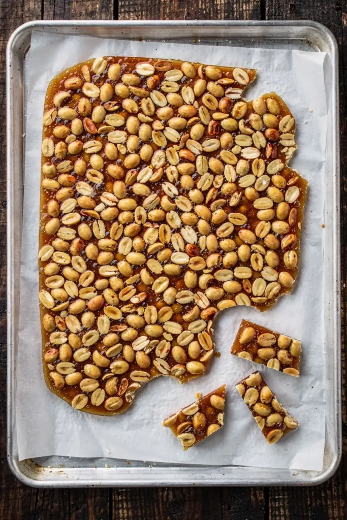 Overhead tray of set sugar-free peanut brittle with a few pieces snapped off